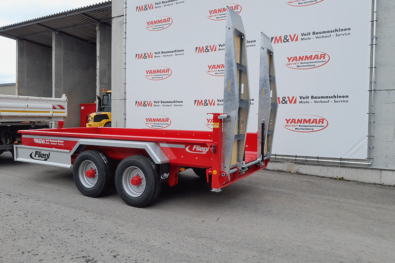 Der Fliegl TTS 89 Tandemanhänger im Baustelleneinsatz als starker und zuverlässiger Partner für den sicheren Transport von Baumaschinen und Material.