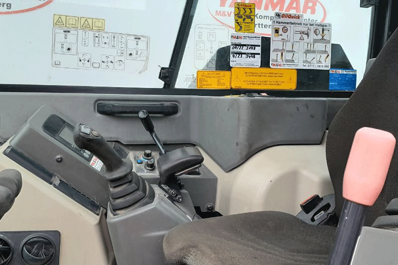 Innenraum des Yanmar SV 100-2 mit OilQuick OQ 45 – moderne Fahrerkabine mit ergonomischer Joystick-Steuerung, übersichtlichem Display und hohem Bedienkomfort für effizientes Arbeiten auf anspruchsvollen Baustellen im Tief- und Hochbau.