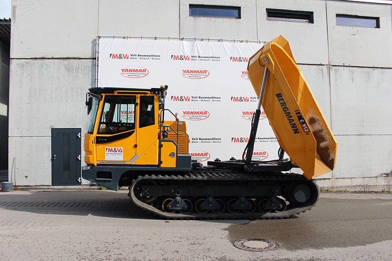 Der Bergmann C 912 Rundkipper Kettendumper im gekippten Zustand mit angehobener Rundkippmulde zum kontrollierten Entladen von Material.