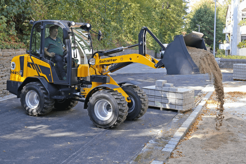 Radlader Schäffer 42445 S schüttet Sand aus