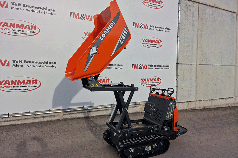 Cormidi C13.85 HI Kettendumper im gekippten Zustand auf der Baustelle – hydraulisch kippbare Mulde beim Entladen von Erde und Schüttgut, kompakter Raupendumper mit hoher Nutzlast für effizienten Materialtransport im Tiefbau und GaLaBau