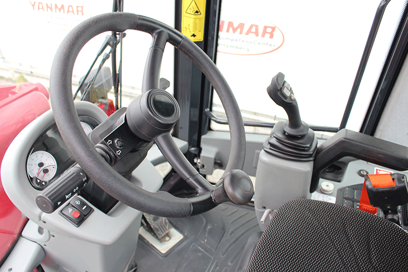 Bedienbereich des Yanmar V 70 Schwenkladers mit ergonomischem Joystick, übersichtlichem Display und komfortabler Fahrerkabine für präzises und effizientes Arbeiten auf der Baustelle.