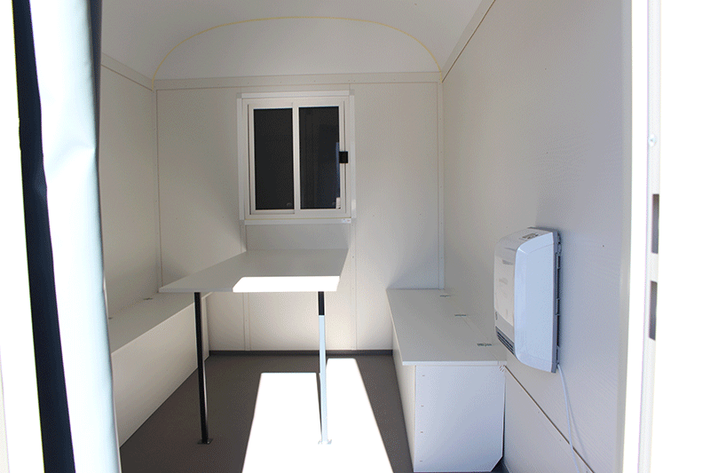Innenraum des Rasant BME C21S Bauwagens mit Sitzbänken, Tisch, Stauraum und robuster Ausstattung – ideal als Aufenthalts- und Mannschaftswagen auf der Baustelle